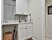 Functional laundry room with a sink, cabinets, and a tiled backsplash at 314 Sandalin Ln, Peachtree City, GA 30269