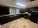 L-shaped kitchen with dark cabinetry and tile floors at 3246 Wallace Lake Rd, Douglasville, GA 30135