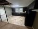 Open kitchen features dark cabinetry, tile floors, and black appliances at 3246 Wallace Lake Rd, Douglasville, GA 30135