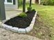 Detailed view of the mulched flower bed on the front porch, bordered by gray stones at 5507 Flat Shoals Pkwy, Decatur, GA 30034