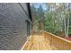 Wooden deck overlooking backyard with dark brick wall at 1240 Spalding Dr, Sandy Springs, GA 30350