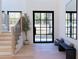 Bright entryway with stylish bench, light wood floors, and modern staircase at 1240 Spalding Dr, Sandy Springs, GA 30350