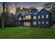 Dark-colored two story home with warm lighting, showcasing modern design at 1240 Spalding Dr, Sandy Springs, GA 30350