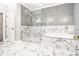 Bright bathroom with glass-enclosed shower, soaking tub, and marble tile accents at 1350 Eryn Cir, Suwanee, GA 30024