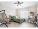 Cozy bedroom with a ceiling fan, a large window, and a hanging chair for relaxation at 1350 Eryn Cir, Suwanee, GA 30024