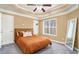 Bedroom with tray ceiling, large window, and plush gray carpeting at 1350 Eryn Cir, Suwanee, GA 30024