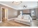 Bright bedroom with hardwood floors, ceiling fan, and seating area in front of the bed at 1350 Eryn Cir, Suwanee, GA 30024