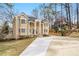 Attractive two-story home with inviting columned porch, lush landscaping, and curved driveway at 1350 Eryn Cir, Suwanee, GA 30024