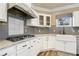 Charming kitchen features white cabinets, granite countertops, stainless steel appliances, and gray backsplash at 1350 Eryn Cir, Suwanee, GA 30024