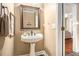 Charming half bathroom features pedestal sink, decorative mirror, and neutral tones at 1350 Eryn Cir, Suwanee, GA 30024