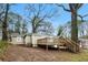 View of the backyard featuring a wood deck attached to the home surrounded by mature trees and natural landscaping at 884 Custer Se Ave, Atlanta, GA 30316