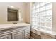 Bathroom featuring glass block window, modern sink/vanity, and tiled shower at 884 Custer Se Ave, Atlanta, GA 30316