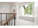 Light-filled hallway with wood railing, carpet, and view of bedroom at 18 Ivy Ne Rdg, Atlanta, GA 30342