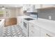 Modern white kitchen with hexagon tile floor, quartz countertops, and gold accents at 18 Ivy Ne Rdg, Atlanta, GA 30342