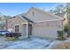 Tan two-story home with a two-car garage and manicured landscaping at 630 Eagles Lndg, Woodstock, GA 30188