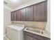 Laundry room with dark brown cabinets, granite countertop, and a utility sink at 630 Eagles Lndg, Woodstock, GA 30188