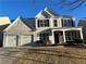 Two-story house with gray siding, two-car garage, and stone accents at 681 Courageous Ct, Lawrenceville, GA 30043