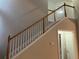 Elegant staircase with wood railing and carpeted steps at 681 Courageous Ct, Lawrenceville, GA 30043