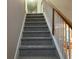 Gray carpeted staircase with wood railing at 681 Courageous Ct, Lawrenceville, GA 30043