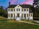 Charming two-story white home with black shutters and a well-manicured lawn at dusk at 2907 Wickford Nw Dr, Kennesaw, GA 30152