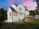 Rear view of a two-story white home with a deck, two-car garage, and lush lawn at 2907 Wickford Nw Dr, Kennesaw, GA 30152