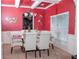 Bright dining room with a glass table and six chairs, red walls, and large window at 15 Blanket Pass, Covington, GA 30016