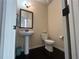 Small powder room with pedestal sink, toilet and dark floors at 15 Blanket Pass, Covington, GA 30016