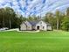 Brick house with a large green lawn and driveway at 5710 Breitling Dr, Cumming, GA 30028