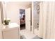 Charming bathroom with patterned shower and modern vanity, with view through doorway to bedroom at 2575 Baker Nw Rd, Atlanta, GA 30318