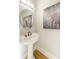 Small bathroom with pedestal sink, art, and hardwood floor at 10444 Park Walk Pt, Alpharetta, GA 30022