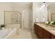 Spa-like bathroom with double sinks, granite counters, and a large soaking tub at 10444 Park Walk Pt, Alpharetta, GA 30022