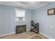 Bright basement room with window, electric fireplace, and shoe rack at 1202 Coan Dr, Locust Grove, GA 30248