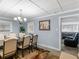 Elegant dining room with chandelier and view into living room at 1202 Coan Dr, Locust Grove, GA 30248