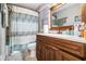 Bathroom featuring a wooden vanity and modern shower with white tile and patterned shower curtain at 4288 Post Rd, Winston, GA 30187