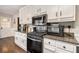 Modern kitchen featuring granite countertops, gas range, and white cabinetry at 4288 Post Rd, Winston, GA 30187