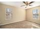 Bright bedroom with carpet, ceiling fan, and two windows at 459 Pleasant Way, Temple, GA 30179