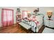 Cozy bedroom with red and white gingham bedding and a metal bed frame at 405 Laurel Spring Ct, Canton, GA 30114