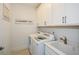 Laundry room with white cabinets, washer, dryer, and a utility sink at 405 Laurel Spring Ct, Canton, GA 30114