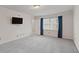 Well-lit bedroom with carpeting, blue curtains, and a mounted television at 4116 River Cliff Chase Se, Marietta, GA 30067