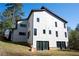 Contemporary two-story home featuring a clean white facade, dark trim, and lush greenery at 4238 Paces Ferry Se Rd, Atlanta, GA 30339