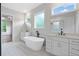 Bright bathroom featuring double vanities with quartz countertops, freestanding tub, and black fixtures at 101 Forsyth Park Ln, Woodstock, GA 30188