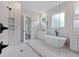 Bright bathroom featuring a glass enclosed shower, freestanding tub, double vanities, and modern finishes at 101 Forsyth Park Ln, Woodstock, GA 30188