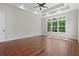 Spacious bedroom with tray ceiling, ceiling fan, hardwood floors and a large window with views of the outdoors at 101 Forsyth Park Ln, Woodstock, GA 30188