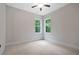 Neutral bedroom features carpet, two windows, a ceiling fan, and white trim and walls at 101 Forsyth Park Ln, Woodstock, GA 30188