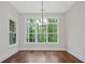 Dining room with large windows offering a view of lush greenery, and elegant lighting at 101 Forsyth Park Ln, Woodstock, GA 30188