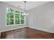 Bright dining room with hardwood floors, a modern chandelier, and large windows overlooking the greenery at 101 Forsyth Park Ln, Woodstock, GA 30188