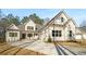 An inviting white home has multiple windows, a side-entry garage and a concrete driveway at 101 Forsyth Park Ln, Woodstock, GA 30188