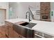 Close-up of a modern stainless steel kitchen sink with a white countertop and wooden cabinets at 101 Forsyth Park Ln, Woodstock, GA 30188