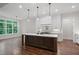 Bright kitchen featuring a large island, modern pendant lights, and stainless steel appliances at 101 Forsyth Park Ln, Woodstock, GA 30188