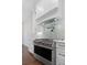 Close-up of a stainless steel stove and hood with white cabinets and subway tile backsplash at 101 Forsyth Park Ln, Woodstock, GA 30188